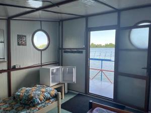 um quarto com uma cama e uma janela num barco em Ponton plutitor em Periprava