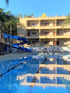 uno scivolo d'acqua in una piscina di fronte a un hotel di Hotel Fazenda Pirâmides ad Atibaia