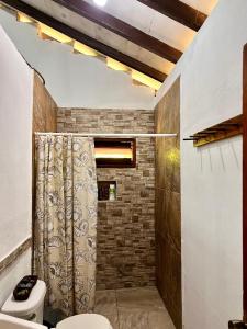 ein Bad mit einem Duschvorhang und einem WC in der Unterkunft Cacerola Beach House in Poneloya