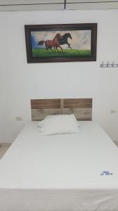 a picture of a horse on the wall above a bed at Hotel La Mata in La Mata +4 photos