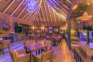 a restaurant with tables and chairs and a ceiling at Embajada Universal By La Eufemia Group in Huay Pix