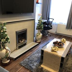 a living room with a fireplace with a tv above it at Comfort Home From Home Bolton Central Hilden St - Sleeps - 10 in Bolton