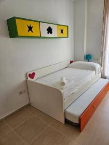 阿爾卡尼斯的住宿－MEQUEDO CALLE MAYOR 18，墙上有两面旗帜的一个小床