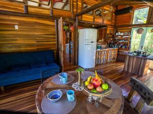 una habitación con una mesa con un bol de fruta en ella en Recanto da Vó Dilma sossego do campo perto do mar, en Imbituba