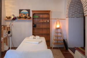 een kamer met 2 bedden en een boekenplank bij Casa Rural Los Sentidos Jimena in Jimena de la Frontera