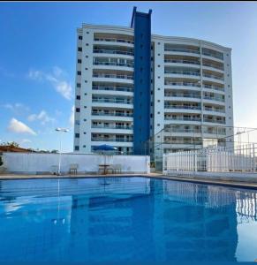 a building with a swimming pool in front of a building at Belíssimo apartamento a 01 km da litorânea in São Luís
