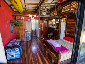 Habitación con 1 dormitorio con cama y tabla de surf. en Recanto da Vó Dilma sossego do campo perto do mar, en Imbituba