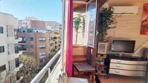 balcón con TV, escritorio y ventana en Modern apartment in Alacant, 60m², wheelchair accessible, en Alicante