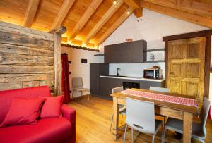 ein Wohnzimmer mit einem roten Sofa und einem Tisch in der Unterkunft Casa Girod - Rascard in Issime