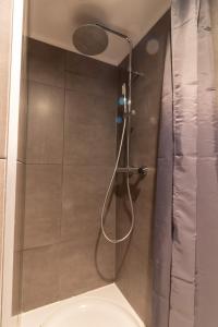 a shower with a glass door in a bathroom at Homey Studios - City Centre in The Hague