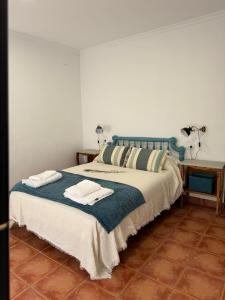 1 dormitorio con 1 cama con 2 toallas en Alojamiento 13 Jotas, en Iniesta