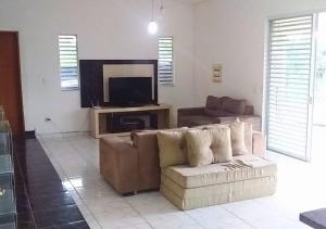a living room with a couch and a flat screen tv at Chácara Jacoob em Itatiba Capacidade p/ 40 Pessoas in Itatiba