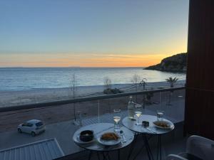 希馬拉的住宿－Anxhelos Hotel，一张带食物的桌子,享有海滩美景