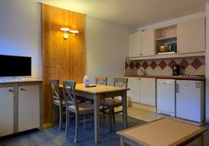 een keuken met een tafel en stoelen in een kamer bij travelski home classic - Résidence La Muzelle in Les Deux Alpes