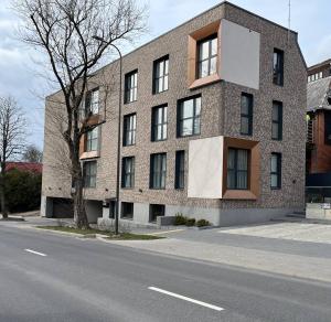 un gran edificio de ladrillo en el lateral de una calle en Slenio Apartamentai, en Kaunas