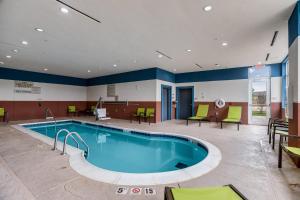 a pool in a hospital with chairs and a table at SpringHill Suites by Marriott Stillwater in Stillwater