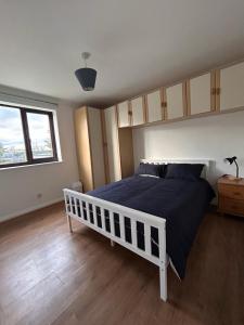 1 dormitorio con 1 cama con edredón azul en Spacious one bed flat in eastlondon with parking and free wifi en Goodmayes
