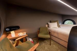 mały pokój z łóżkiem i krzesłem w obiekcie Schmalshuus Module w Luksemburgu