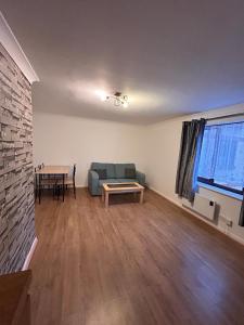 a living room with a couch and a table at Spacious one bed flat in eastlondon with parking and free wifi in Goodmayes