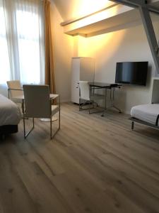 een hotelkamer met een bureau en een televisie bij Hotel de MAGISTRAAT in Willemstad