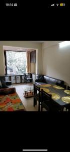 una sala de estar con mesa y una habitación con sofá en Good earth society, en Bombay