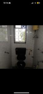 baño con aseo y ventana en Good earth society, en Bombay