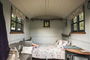 a room with a bed and a table and windows at Robins Rest in the North York Moors in Rosedale Abbey