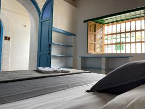 a bedroom with two beds and a blue door at Hostel Once Once in Villa de Leyva