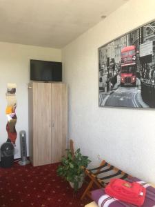 a living room with a red double decker bus on the wall at Landhaus Nauenburg in Heere