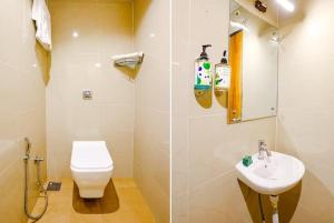 a bathroom with a toilet and a sink at Hotel Wind Flower Inn Near International Airport in Mumbai