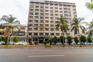 een groot gebouw met palmbomen ervoor bij Umuarama Plaza Hotel by Castelo Itaipava in Goiânia