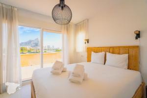 sypialnia z białym łóżkiem i dużym oknem w obiekcie CostaBlancaDreams Casa Colari 4 in Calpe w mieście Calpe
