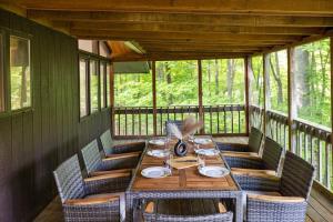 a wooden table on a screened in porch with chairs at Large home with indoor heated pool! 