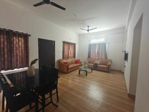 a living room with a piano and a couch at Urban Nest Residence in Mysore