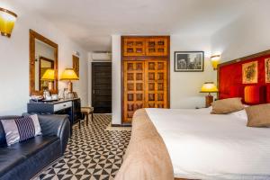 フエンヒロラにあるBoutique Hotel Las Islasのベッドとソファ付きのホテルルーム