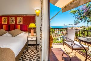 a bedroom with a bed and a balcony with a table at Boutique Hotel Las Islas in Fuengirola