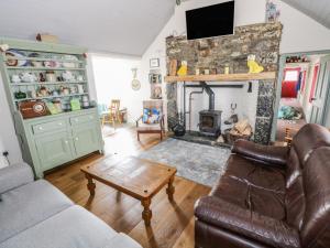 a living room with a couch and a fireplace at Freemans Cottage in Enniscrone