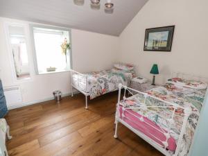 een slaapkamer met 2 bedden en een raam bij Freemans Cottage in Enniscrone