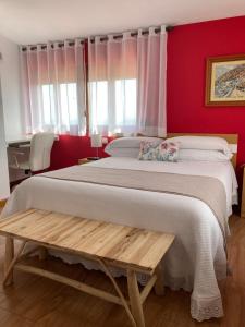 a bedroom with a large bed and red walls at Posada Las Torres in Yuso