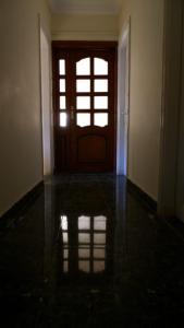 an empty room with a door and a reflection in the floor at غرفة هادئة بمنزل قريب من المطار in Cairo