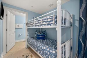 a childs bedroom with bunk beds and blue walls at Palazzo #505 by Nautical Properties in Panama City Beach