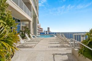 a swimming pool with lounge chairs next to a building at Palazzo #505 by Nautical Properties in Panama City Beach