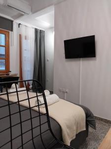 a bedroom with a bed and a flat screen tv on the wall at Homdwell Fine Living 2 in Ermoupoli