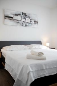 a white bed with two towels on top of it at Villa Laura in Nadin