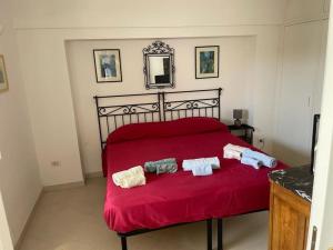 a bedroom with a red bed with two towels on it at villa timpone in Anacapri