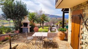 a patio with a table and chairs and a stove at La Valle Del Sole Country House in SantʼIppolito