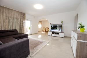 a living room with a couch and a television at Villa Laura in Nadin