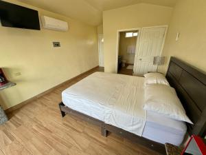 a bedroom with a large bed and a flat screen tv at Cabañas Colibri in Valle de Guadalupe