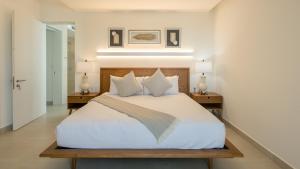 a bedroom with a large white bed with two tables at Relax in Costa Divina LV 53 Brand New by Kivoya in Puerto Peñasco