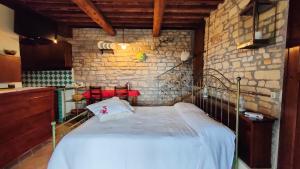 1 dormitorio con 1 cama en una pared de piedra en La Valle Del Sole Country House, en SantʼIppolito